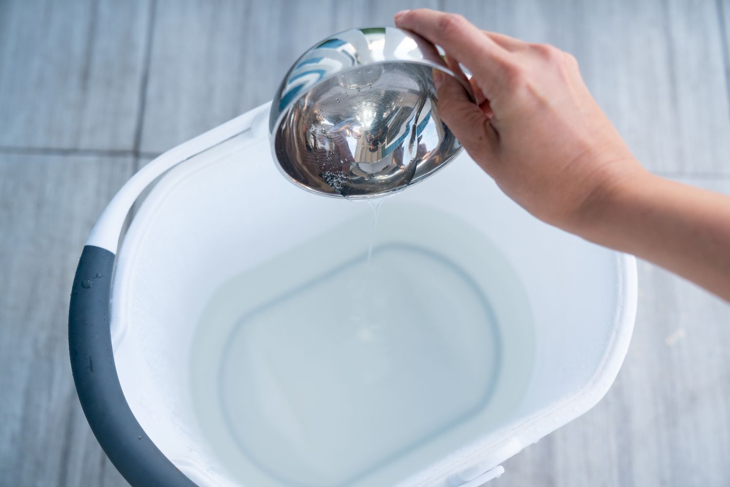 Wool detergent mixed into a container of water to create a cleaning solution.