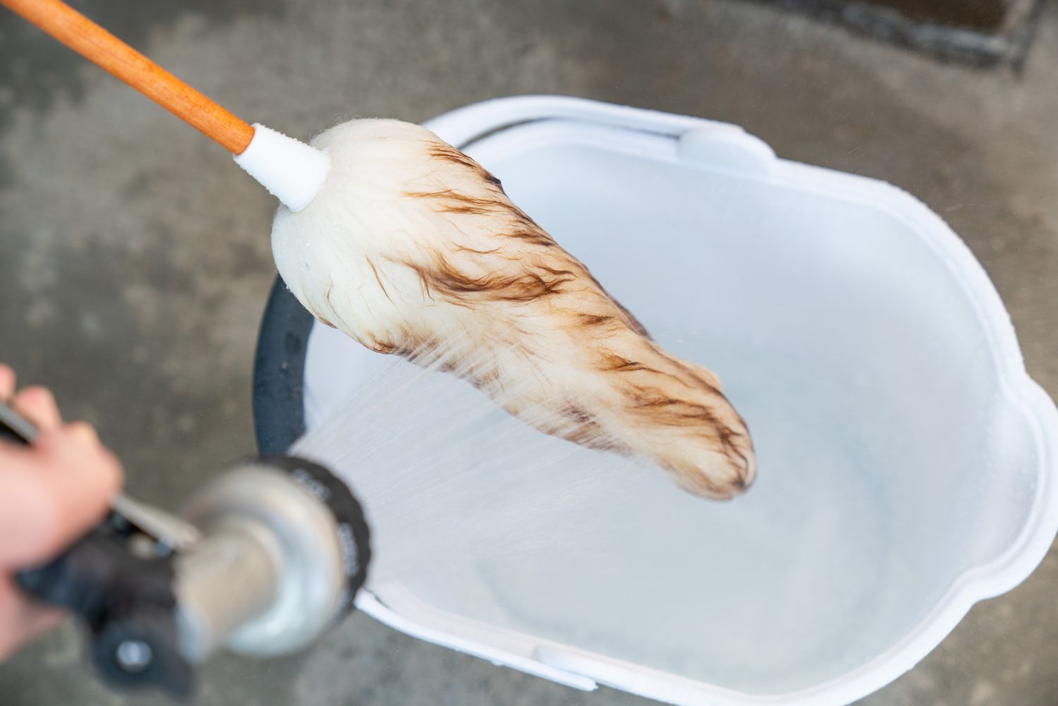 A wool duster soaked in cold water above a bucket.