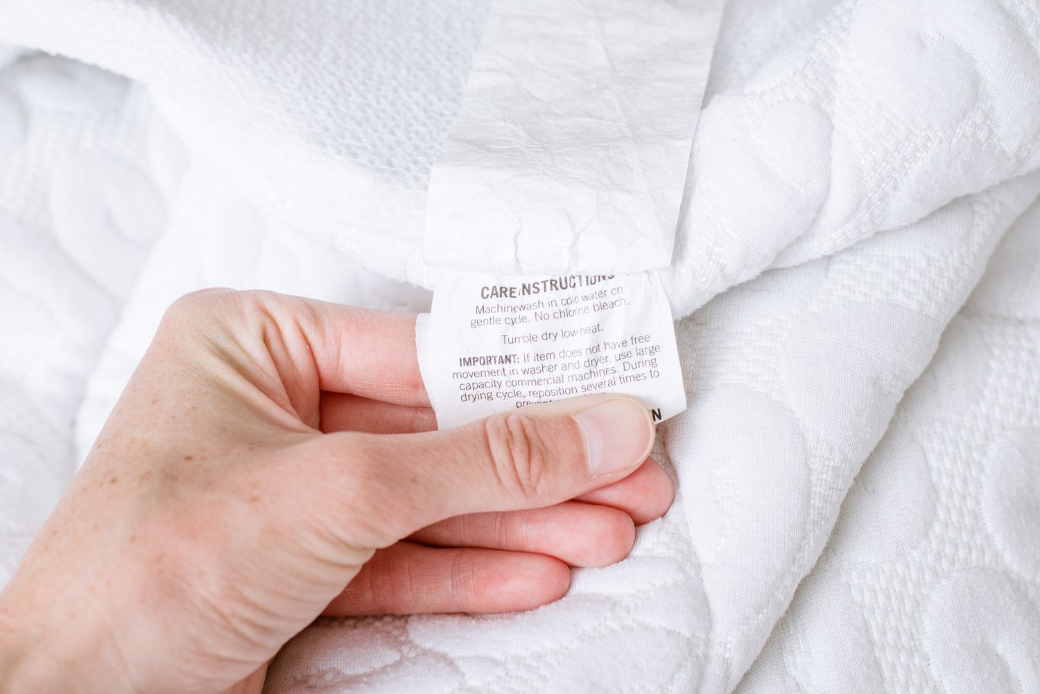 Inspecting the mattress protector label prior to the cleaning process.