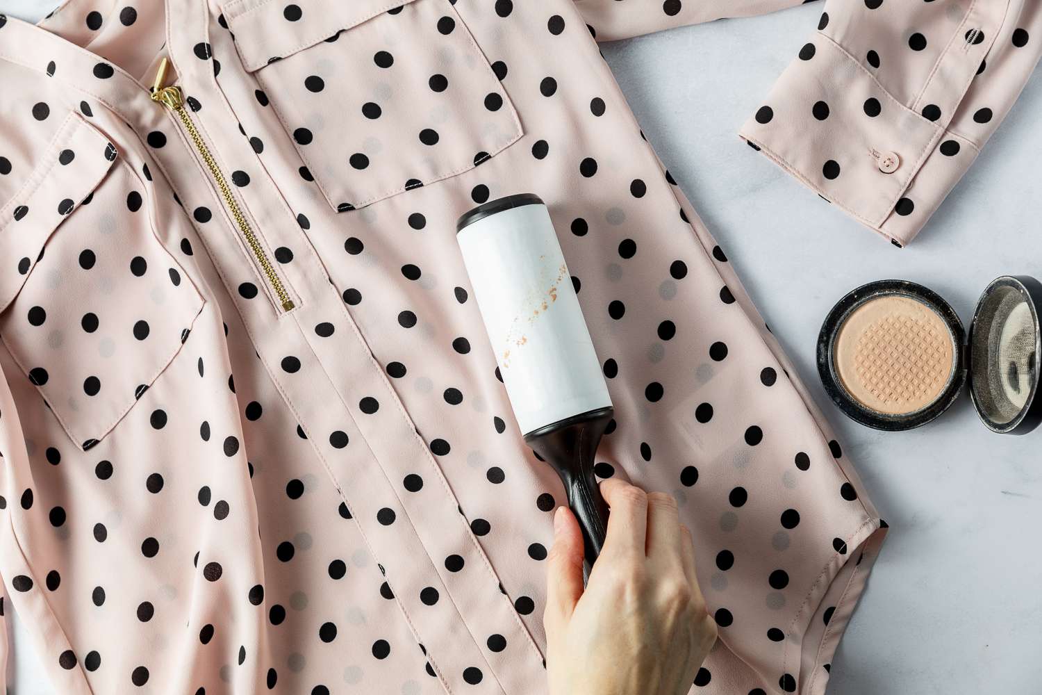 Employing a lint roller to eliminate makeup powder marks.