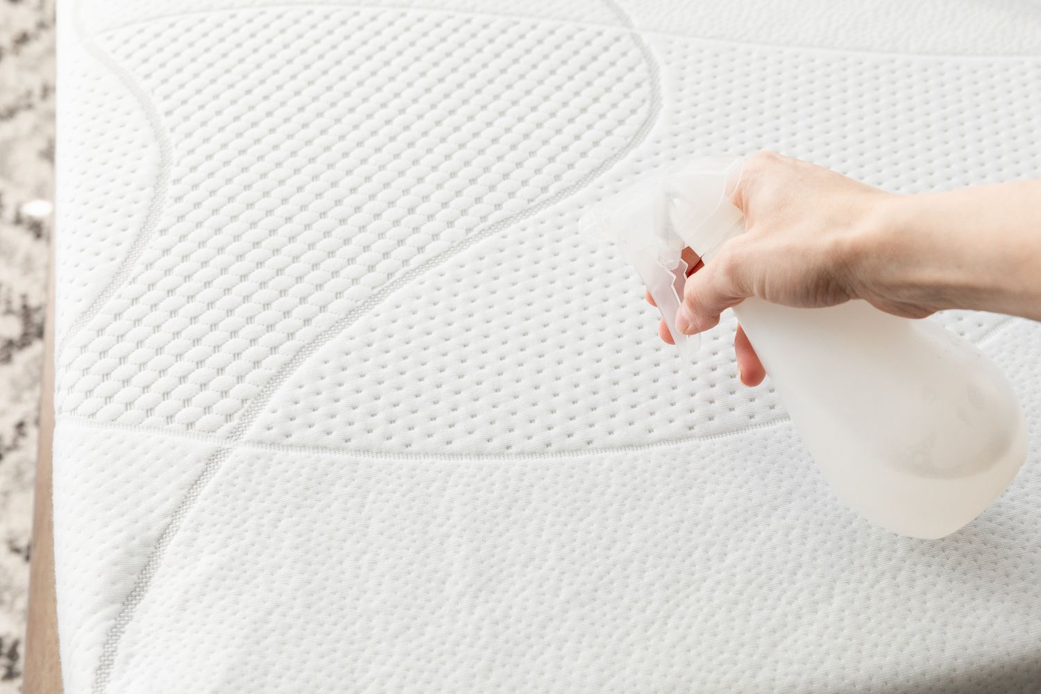 Applying distilled white vinegar to the mattress using a spray.